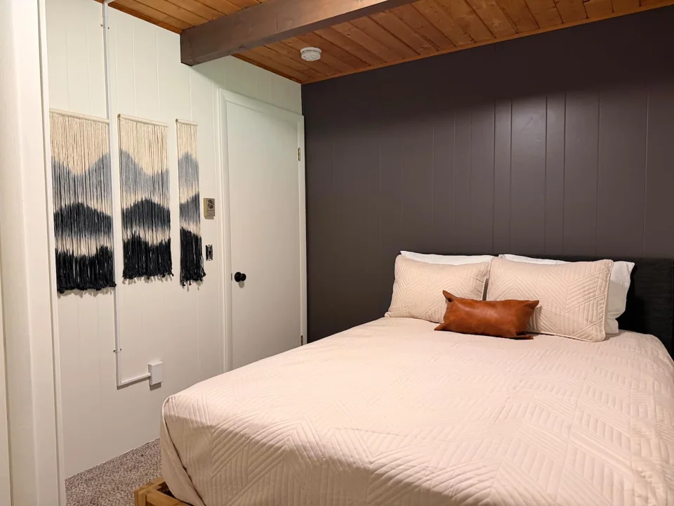 Queen bedroom with warm wood ceilings