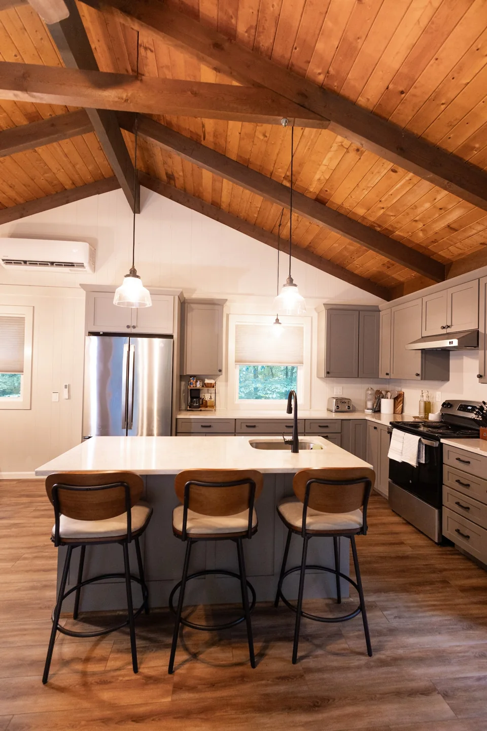 Kitchen and living spaces beneath a vaulted timber ceiling