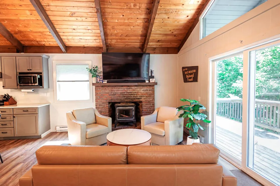 Open living space with warm wood ceilings and deck access